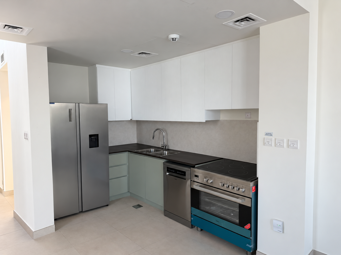 Completed white and sage two-tone apartment kitchen